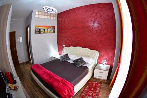 um quarto com uma cama com uma parede vermelha em Royal Termini em Roma