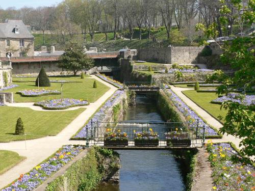a bridge over a river in a park with flowers at Azureva Kerjouanno in Arzon
