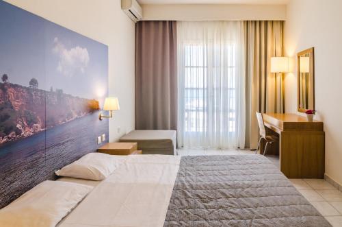 a hotel room with a large bed and a desk at Hotel Nereides in Patitiri
