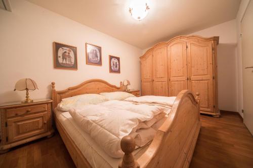 a bedroom with a wooden bed and a wooden dresser at I dr Rehwiesa A16 in Arosa
