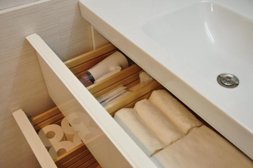 a drawer in a bathroom with towels and toilet paper at Senlax Inn Osaka in Osaka