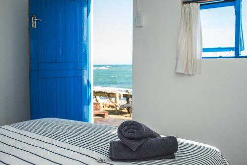 uma toalha sentada numa cama num quarto com o oceano em Koensrust Beach Shack em Vermaaklikheid