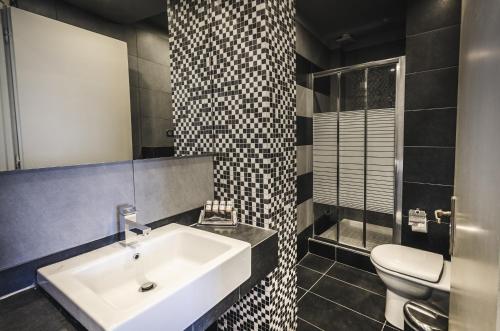 a bathroom with a sink and a toilet at Hotel Nereides in Patitiri