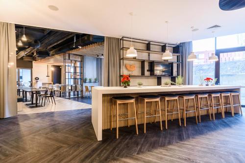 a large kitchen with a bar with stools at Arche Hotel Lublin in Lublin
