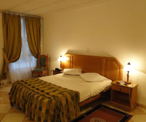 a bedroom with a large bed and a window at Hotel El Biar in Alger