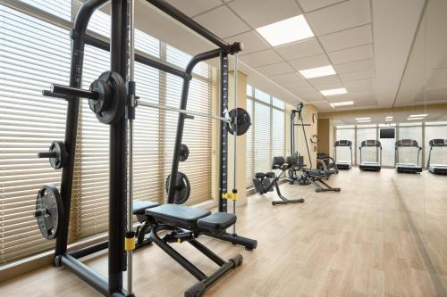 a gym with several treadmills and weights at Ramada by Wyndham Manama City Centre in Manama