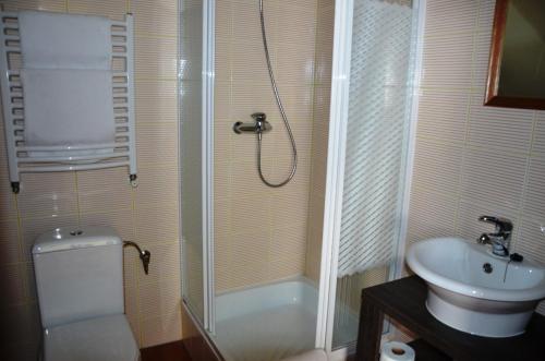 a bathroom with a shower and a toilet and a sink at Stara Szkoła w Harszu in Pozezdrze