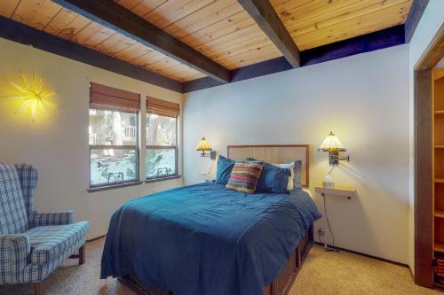 Un dormitorio con una cama y una silla y una ventana. en Kingswood Retreat, en Kings Beach