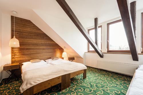 a attic bedroom with two beds and a staircase at Hotel Sharingham in Brno