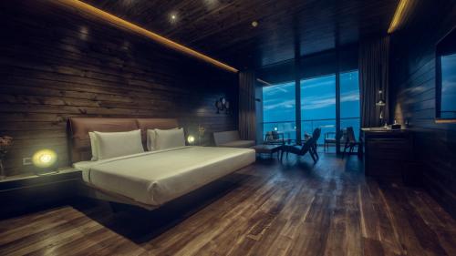a bedroom with a large bed and a table and chairs at Pledge Scape in Negombo