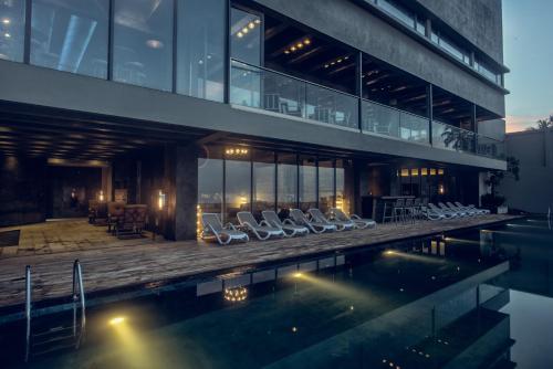 a house with a swimming pool and lounge chairs at Pledge Scape in Negombo
