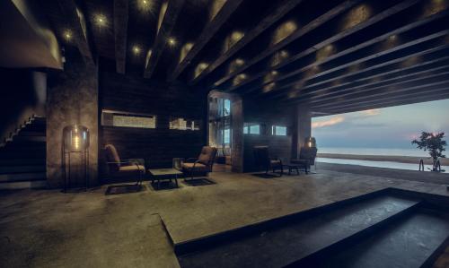a lobby with chairs and a table and the ocean at Pledge Scape in Negombo