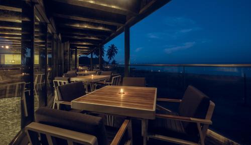 a restaurant with tables and chairs on a balcony at night at Pledge Scape in Negombo