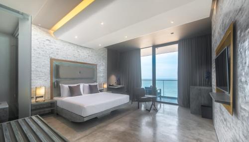 a bedroom with a bed and a view of the ocean at Pledge Scape in Negombo