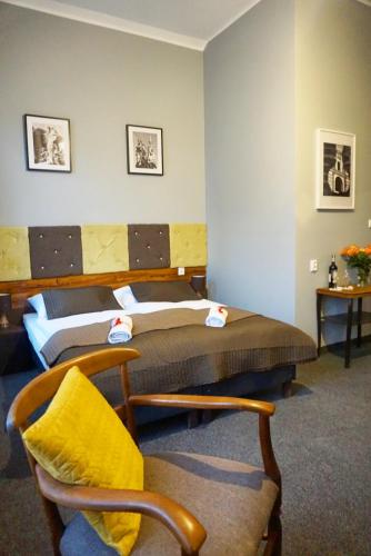 a bedroom with two beds and a chair at Expolis Residence - City Center - 24h POZNAŃ GŁÓWNY #betterthanyourEX in Poznań