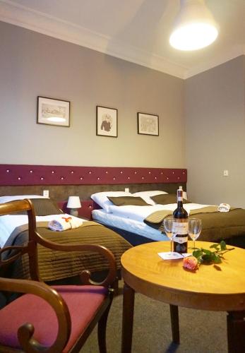 a hotel room with two beds and a table with a bottle of wine at Expolis Residence - City Center - 24h POZNAŃ GŁÓWNY #betterthanyourEX in Poznań
