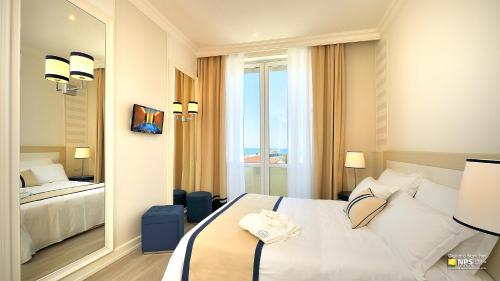a hotel room with a bed and a large window at Grand Hotel & Riviera in Lido di Camaiore
