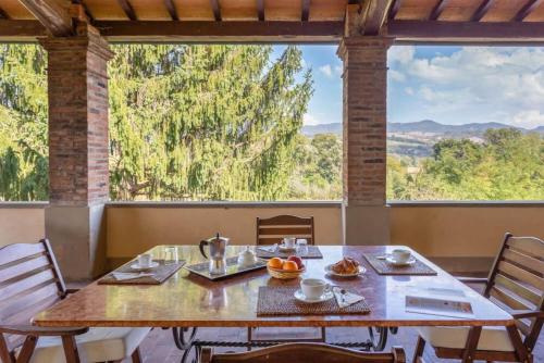 a dining room with a table and a large window at Villa Eugenia Tuscany with private Pool, Sauna & Gym in Vicchio