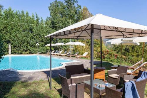 a pool with umbrellas and chairs and a table and a pool at Villa Eugenia Tuscany with private Pool, Sauna & Gym in Vicchio