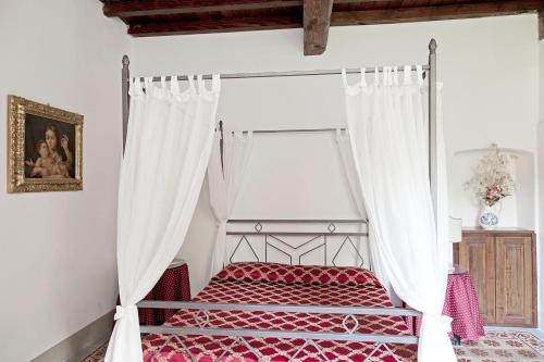 a bedroom with a red bed with a canopy at Villa Eugenia Tuscany with private Pool, Sauna & Gym in Vicchio