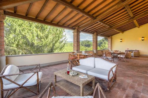 a living room with chairs and tables and large windows at Villa Eugenia Tuscany with private Pool, Sauna & Gym in Vicchio
