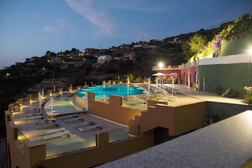 a view of a swimming pool at night at GH Avalon Sikani in Gioiosa Marea