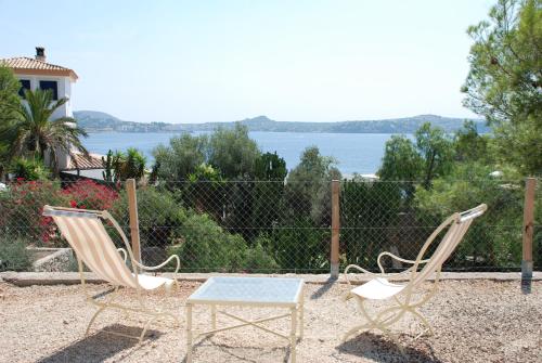 two chairs and a table and a fence at Hotel Petit Cala Fornells in Paguera