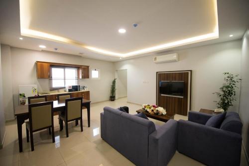 a living room with a couch and a dining room at Al Nakhla Aparthotel in Al Hofuf