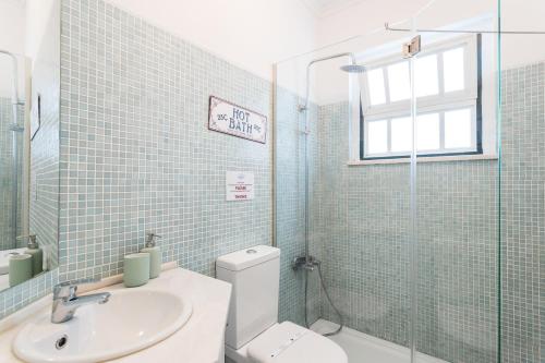 リスボンにあるFLH Alfama Charming Flatのバスルーム(トイレ、洗面台付)、窓が備わります。