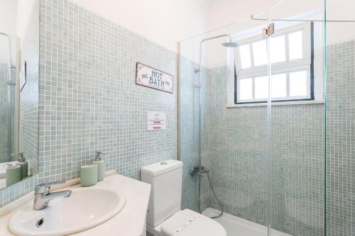 a bathroom with a toilet and a sink and a window at FLH Alfama Charming Flat in Lisbon