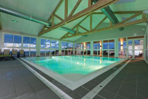 ein großer Pool mit blauem Wasser in einem Gebäude in der Unterkunft Azureva Hendaye in Hendaye