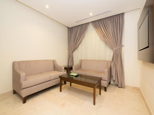 a living room with two chairs and a coffee table at Aster Hotel in Jeddah
