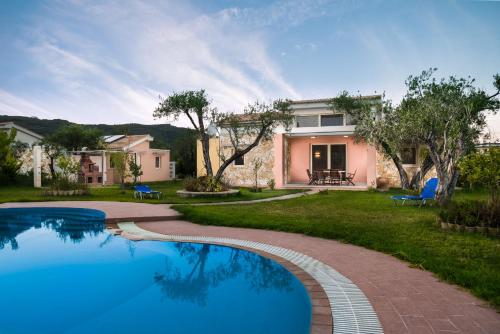 a villa with a swimming pool in front of a house at Three Stars Luxury Villas in Moraitika