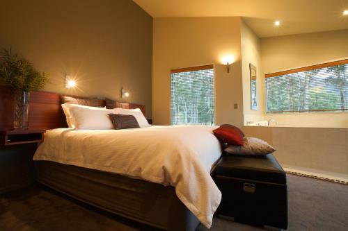 a bedroom with a large bed and a bathroom at Bushland in Halls Gap