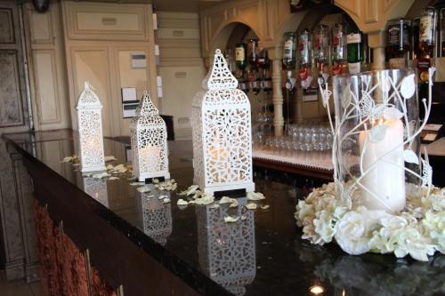 a bar with three white candles on a counter at Greenvale Hotel in Cookstown