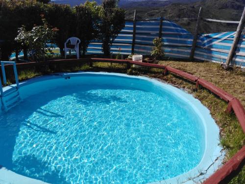 a large pool with blue water in a yard at Cabaña el Coirón in Cochrane