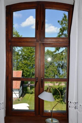 a large wooden door with a lamp and a window at Stara Szkoła w Harszu in Pozezdrze