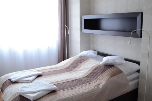 um quarto de hotel com uma cama com toalhas em Apartament Bluszcz em Polanica-Zdrój