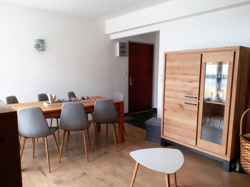 une salle à manger avec une table et des chaises en bois dans l'établissement Résidence Orazur - Appartement de Charme - 2 chambres - Poêle à bois - 2 balcons - Jardin - Parking - Internet - Linge et Ménage en options payantes, à Font-Romeu