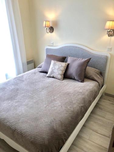 a bed with three pillows on it in a bedroom at LA SUITE ENCHANTÉE Disneyland Paris in Serris