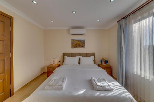 1 dormitorio con 1 cama grande y 2 toallas. en Anatolia Hotel Geyre Karacasu Aydın (Aphrodisias), en Geyre