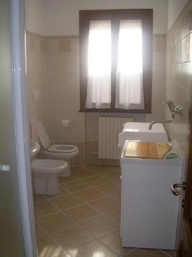 a bathroom with a sink and a toilet and a window at Ariabuona in Moneglia