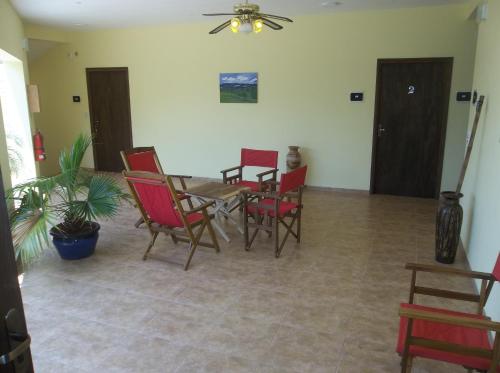 a dining room with red chairs and a table at Posada Maria in Trinidad