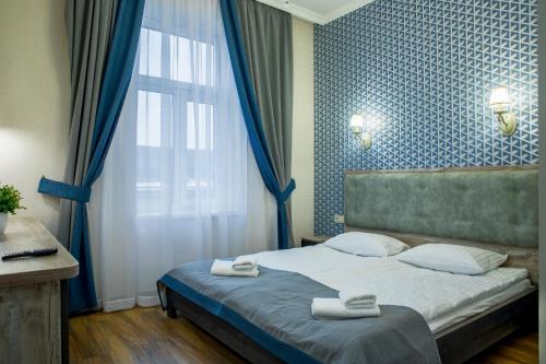 a bedroom with a bed with two towels on it at Mini Hotel Barvy Lvova on Horodotska St. in Lviv