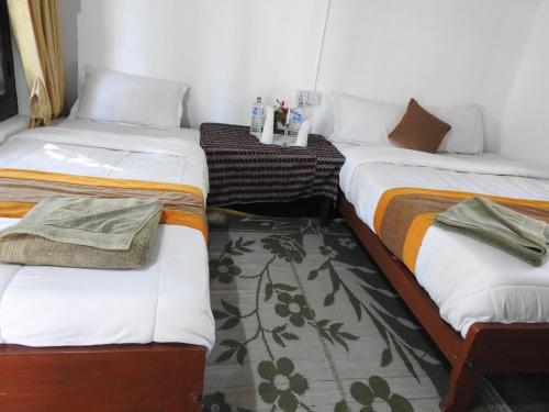 two twin beds in a room with at Rhino Lodge Bardia Pvt Ltd in Bhurkīā