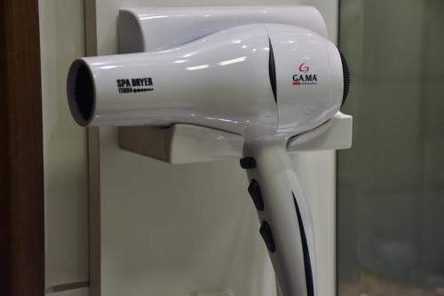 a hair dryer on a stand in front of a mirror at Hotel Due Nobili in Gramado