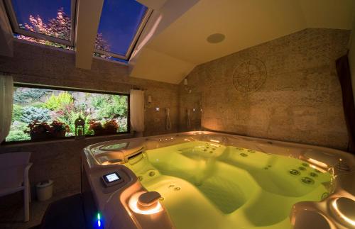 a large tub in a bathroom with two windows at Willa pod Czantorią SPA Ustroń in Ustroń