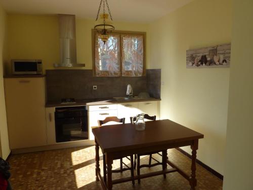 - une cuisine avec une table en bois et une table dans l'établissement Le cerisier, à Millau