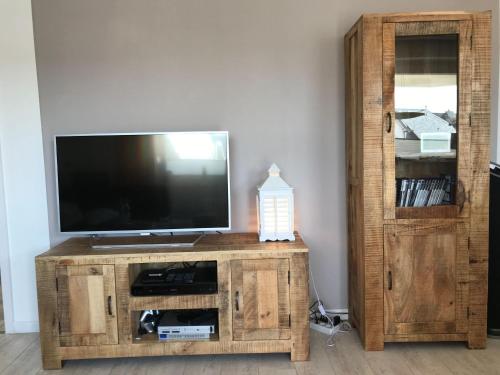 a wooden entertainment center with a flat screen tv at Seebrise-Sylt in Westerland (Sylt)