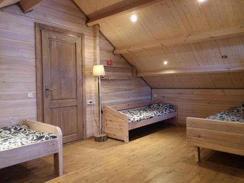 a room with two beds in a wooden cabin at Holiday House & Sauna in Druskininkai in Neravai